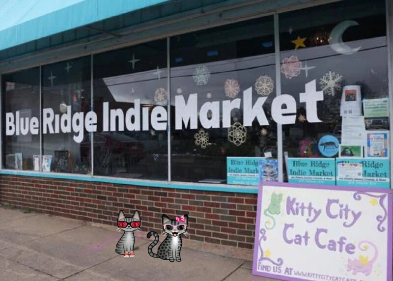 Kitty City Cat Cafe Two cartoon tabby cats in front of the Blue Ridge Indie Market and Kitty City Cat Cafe building.