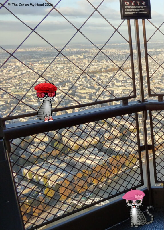 Two cartoon tabby cats atop the Eiffel Tower.