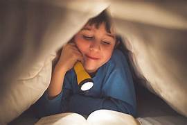 thankful Thursday anniversary poetry Child reading under the covers with a flashlight.